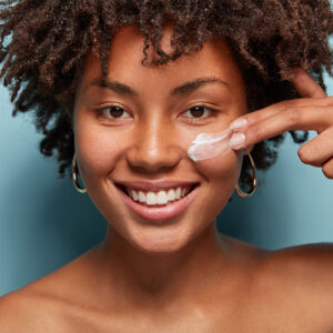 woman putting sunscreen on her cheek