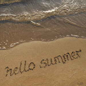 beach with "hello summer" in sand