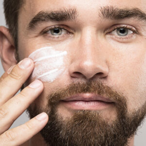 man applying sunscreen on his face